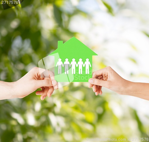 Image of man and woman hands with paper house