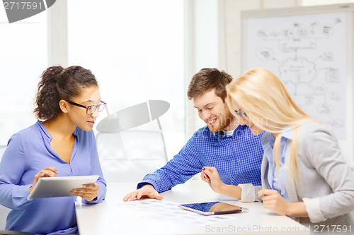 Image of smiling team with table pc and papers working