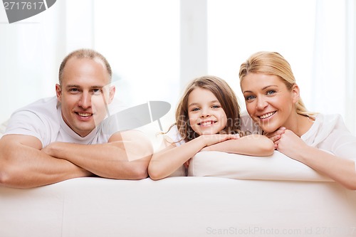 Image of smiling parents and little girl at home