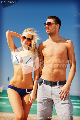 Image of happy couple in sunglasses on the beach