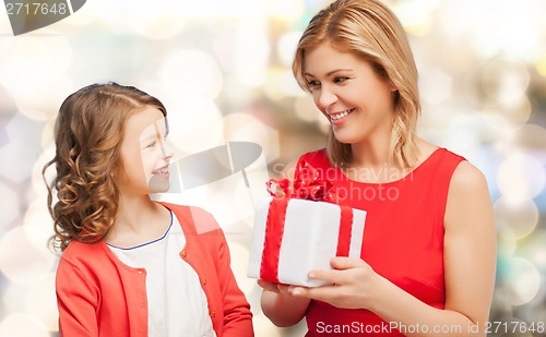 Image of smiling mother and daughter with gift box
