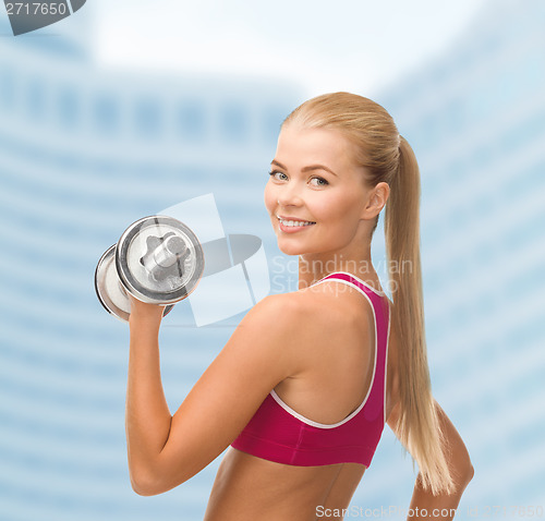 Image of smiling woman with heavy steel dumbbell