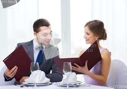 Image of smiling couple with menus at restaurant