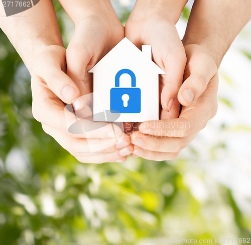 Image of hands holding paper house with lock