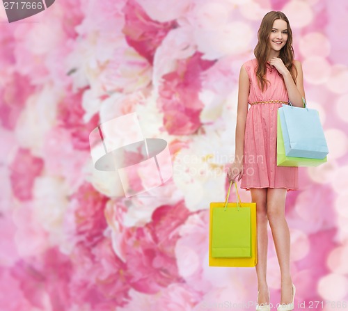 Image of smiling woman in dress with many shopping bags