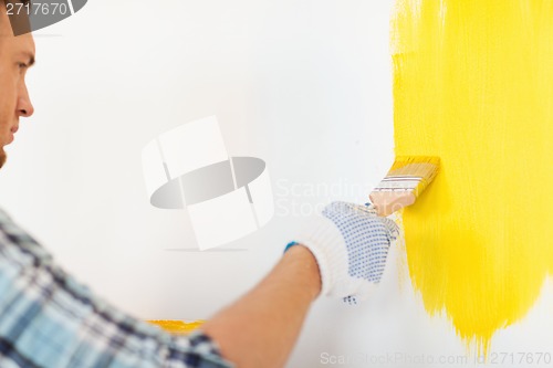 Image of close up of male in gloves holding paintbrush