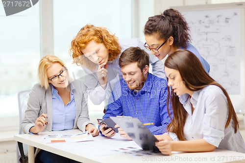 Image of creative team with papers and clipboard at office