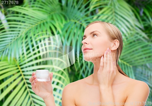 Image of woman applying cream on her skin