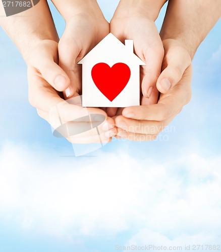 Image of couple hands holding white paper house