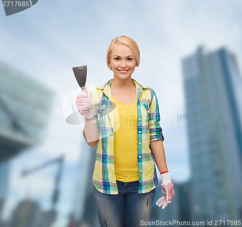 Image of smiling female worker in gloves with spatula