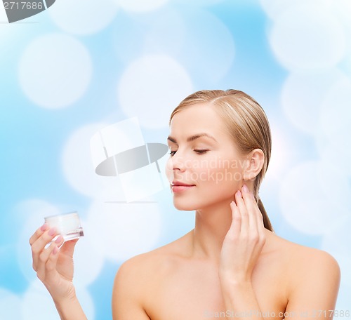 Image of woman applying cream on her skin