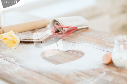 Image of close up of heart of flour on wooden table at home