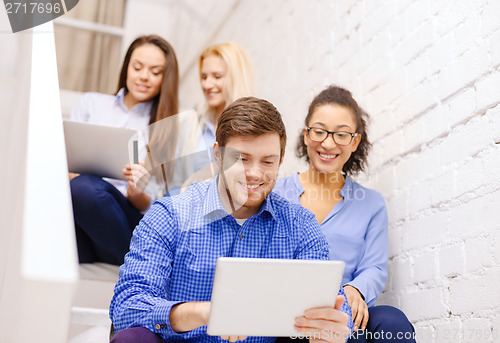 Image of team with tablet pc computer sitting on staircase