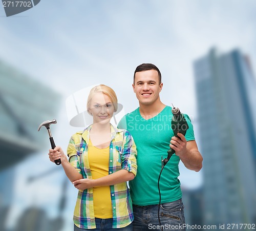 Image of smiling couple with hammer and drill