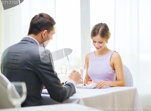 Image of smiling couple eating dessert at restaurant