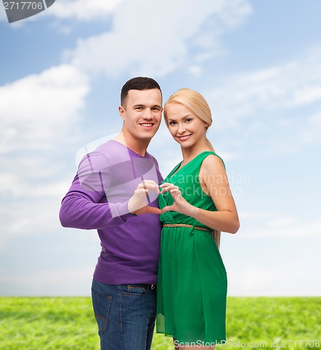 Image of smiling couple showing heart with hands