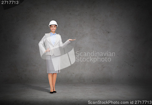 Image of businesswoman in helmet holding something on palm