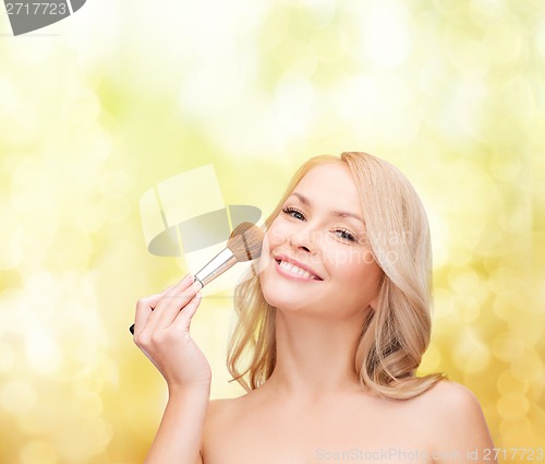 Image of beautiful woman with closed eyes and makeup brush