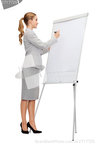 Image of smiling businesswoman writing on flip board