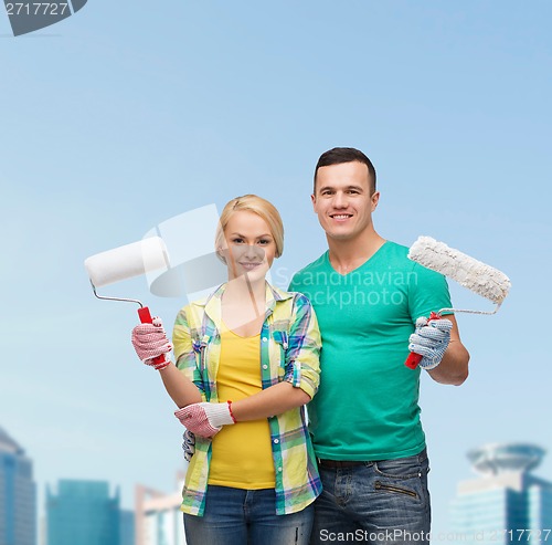 Image of smiling couple in gloves with paint rollers