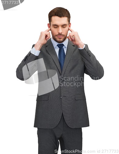 Image of annoyed businessman covering ears with his hands