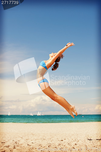 Image of happy jumping woman on the beach