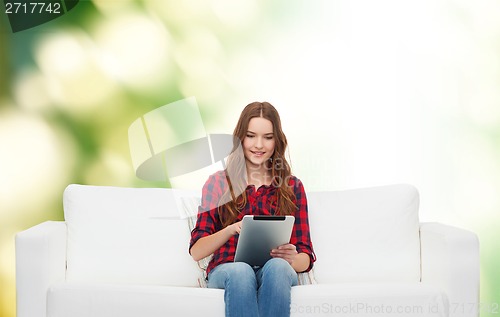 Image of teenage girl sitting on sofa with tablet pc