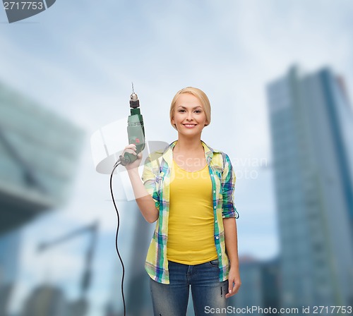 Image of smiling woman with drill machine