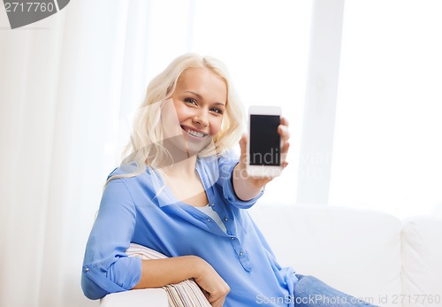 Image of smiling woman with blank smartphone screen at home