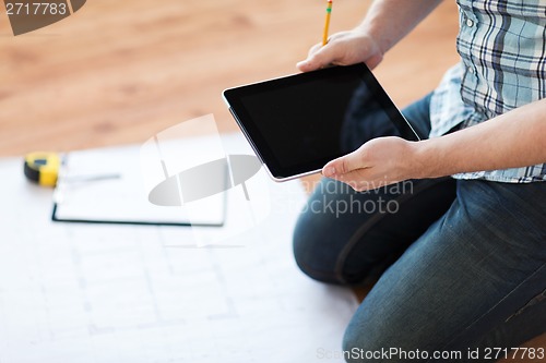 Image of male with tablet pc, blueprint and measuring tape