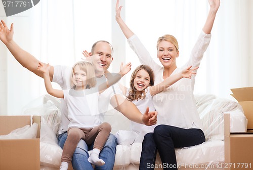 Image of smiling parents and two little girls at new home