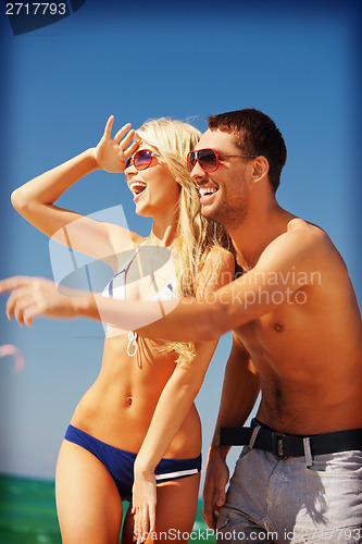 Image of happy couple in sunglasses on the beach