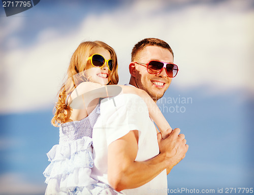 Image of happy father and child in sunglasses over blue sky