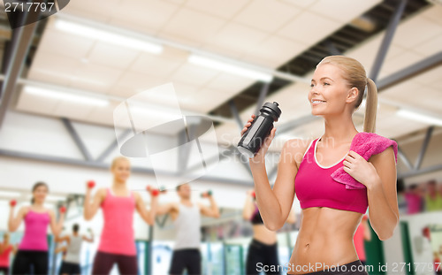 Image of sporty woman drinking water from sportsman bottle