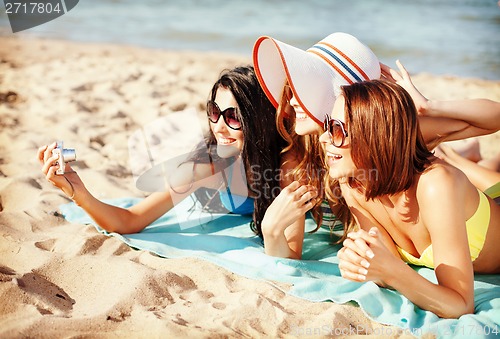 Image of girls making self portrait on the beach