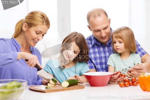 Image of happy family with two kids making dinner at home