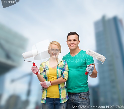 Image of smiling couple in gloves with paint rollers