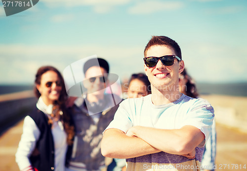 Image of teenager in shades outside with friends