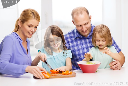 Image of happy family with two kids making dinner at home