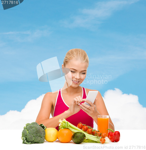 Image of woman with vegetables pointing at smartphone