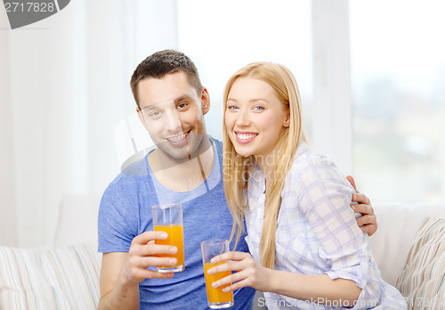 Image of smiling happy couple at home drinking juice