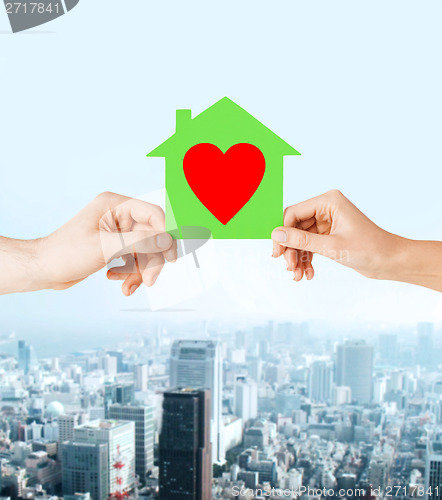 Image of couple hands holding green paper house