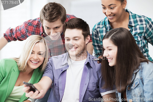 Image of students looking into smartphone at school