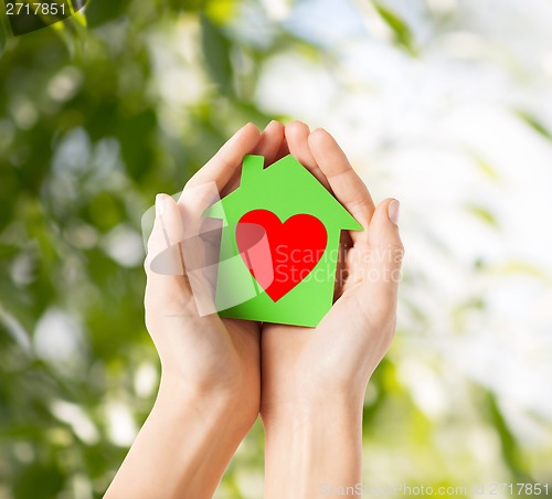 Image of hands holding green paper house