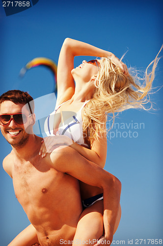 Image of happy couple in sunglasses on the beach