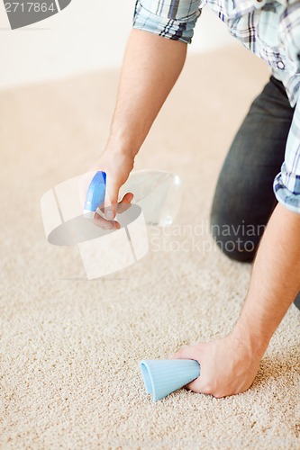 Image of close up of male cleaning stain on carpet