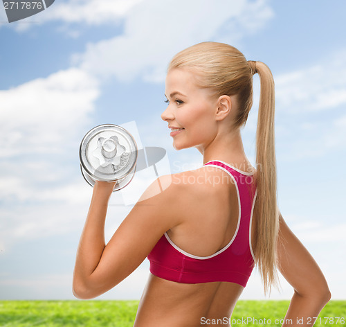 Image of smiling woman with heavy steel dumbbell