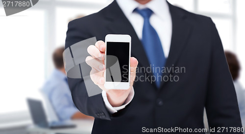 Image of businessman showing smartphone with blank screen
