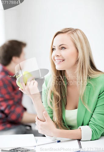 Image of student girl with green apple in college