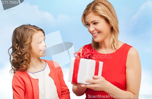 Image of smiling mother and daughter with gift box